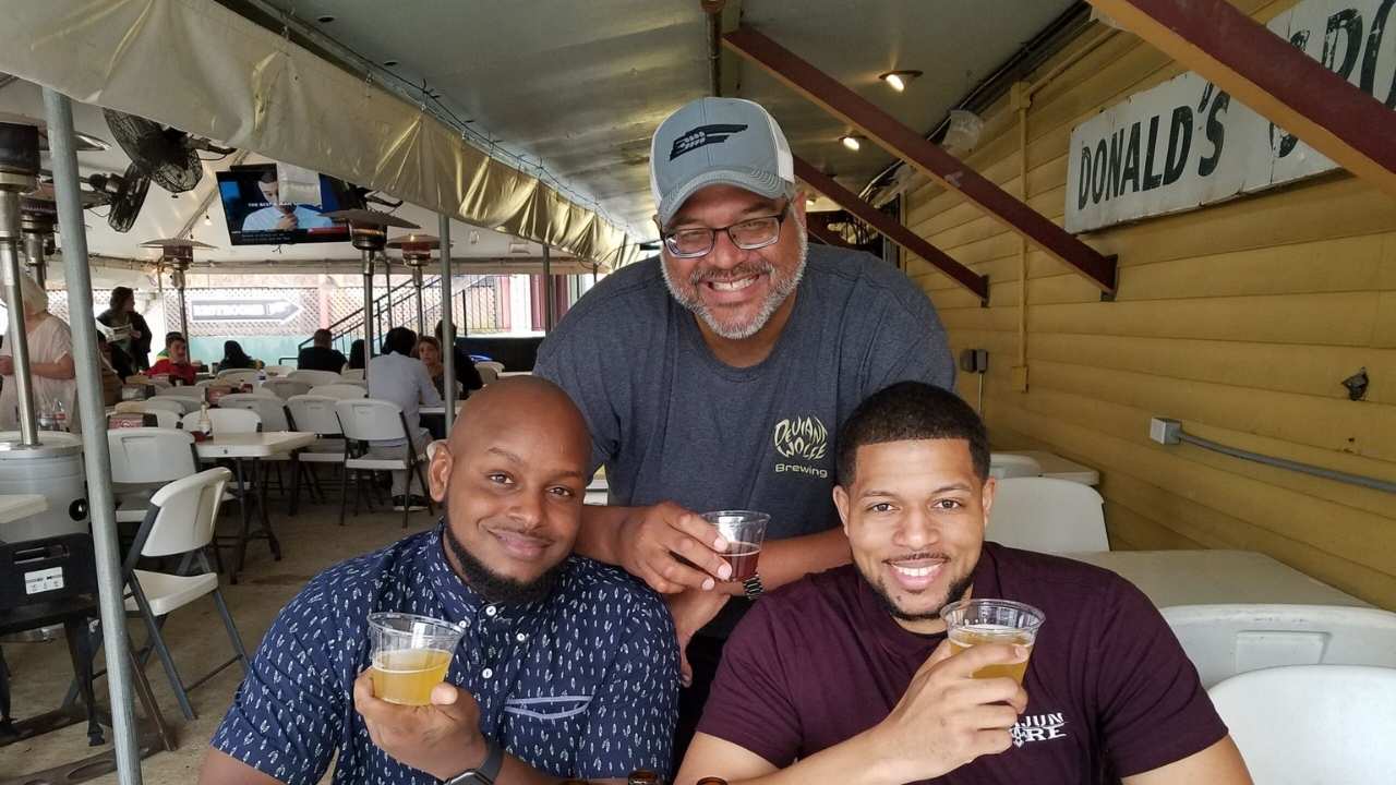 three men holding cups of beer